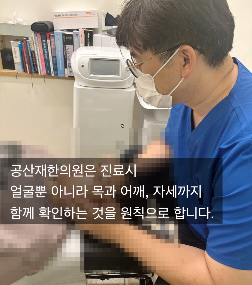 의사가 마스크를 쓰고 환자를 진료하는 모습. 배경에는 책과 의료기기가 보이며, 텍스트로 '공산재한의원은 진료 시 얼굴뿐 아니라 목과 어깨, 자세까지 함께 확인하는 것을 원칙으로 합니다.'라고 적혀 있다.
